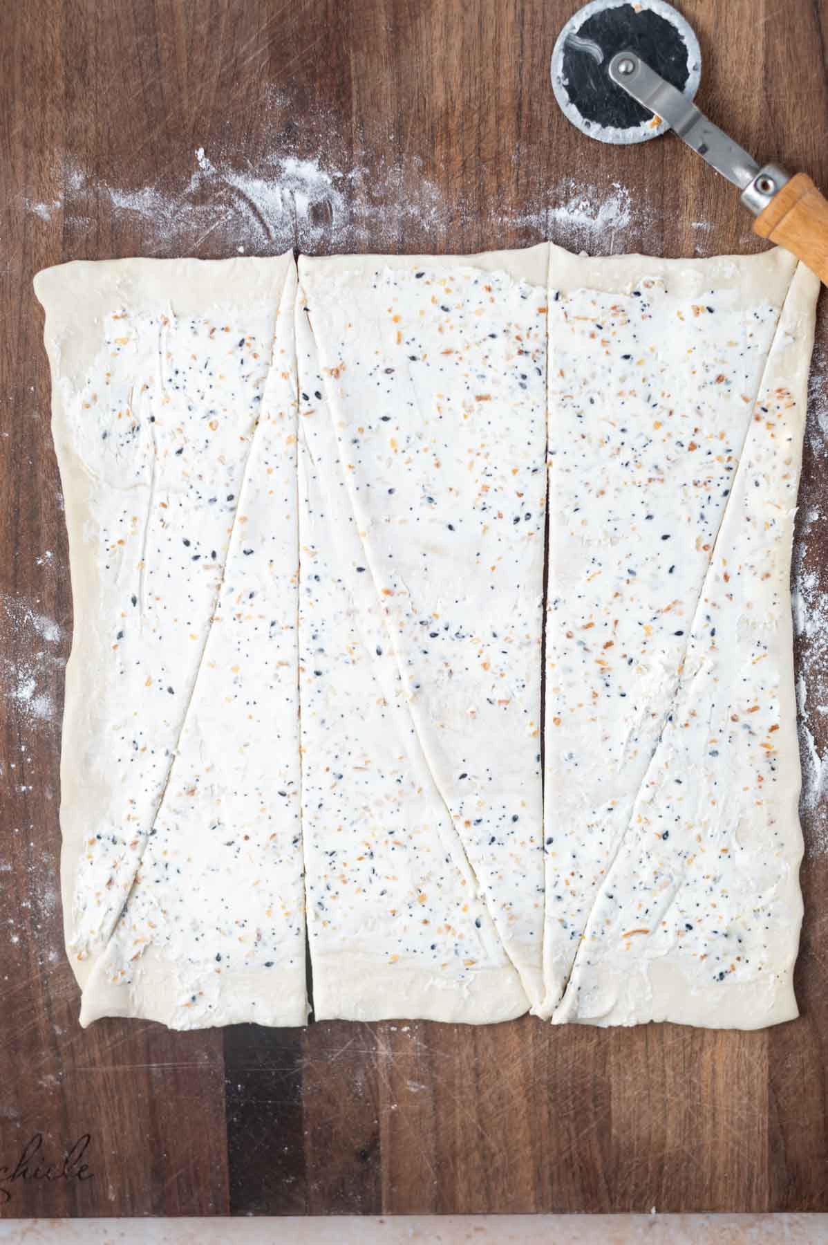 cream cheese and everything bagel seasoning spread on puff pastry and cut into triangles