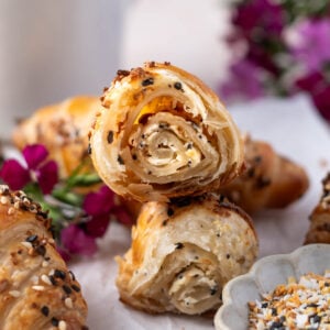croissants on a plate with one broken in half to show layered center