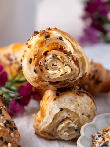 croissants on a plate with one broken in half to show layered center