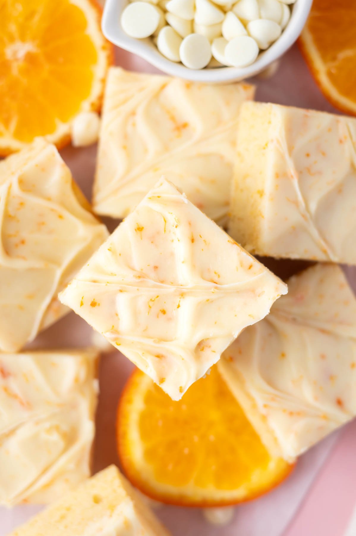 overhead look at orange dream bars on parchment paper with orange slices and white chocolate