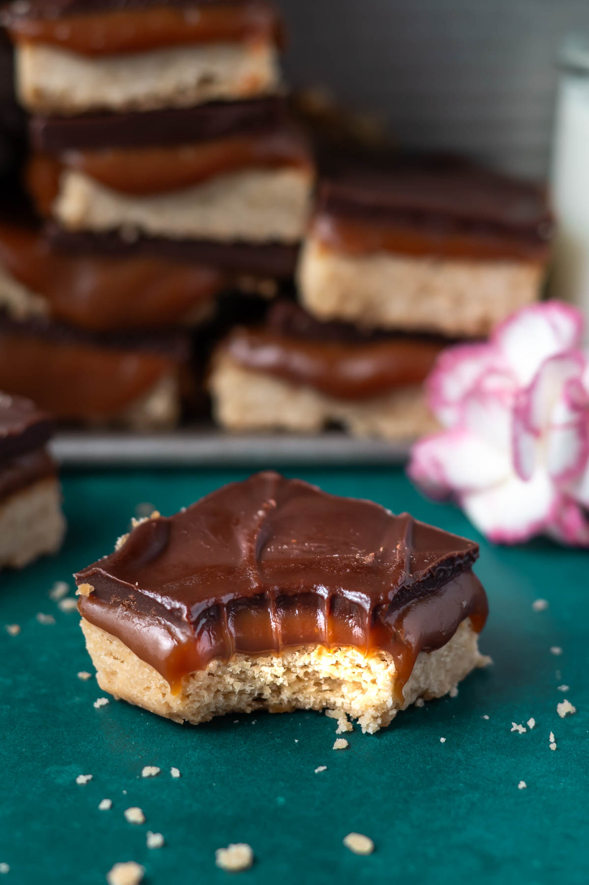 caramel slice bar with a bite missing on a green counter