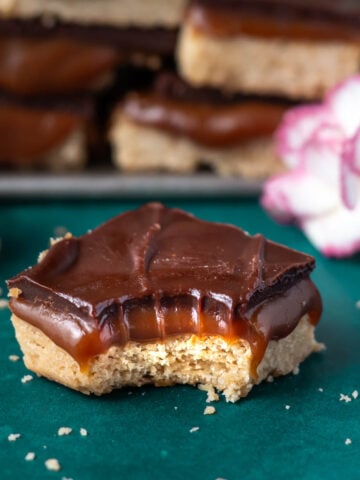 caramel slice bar with a bite missing on a green counter