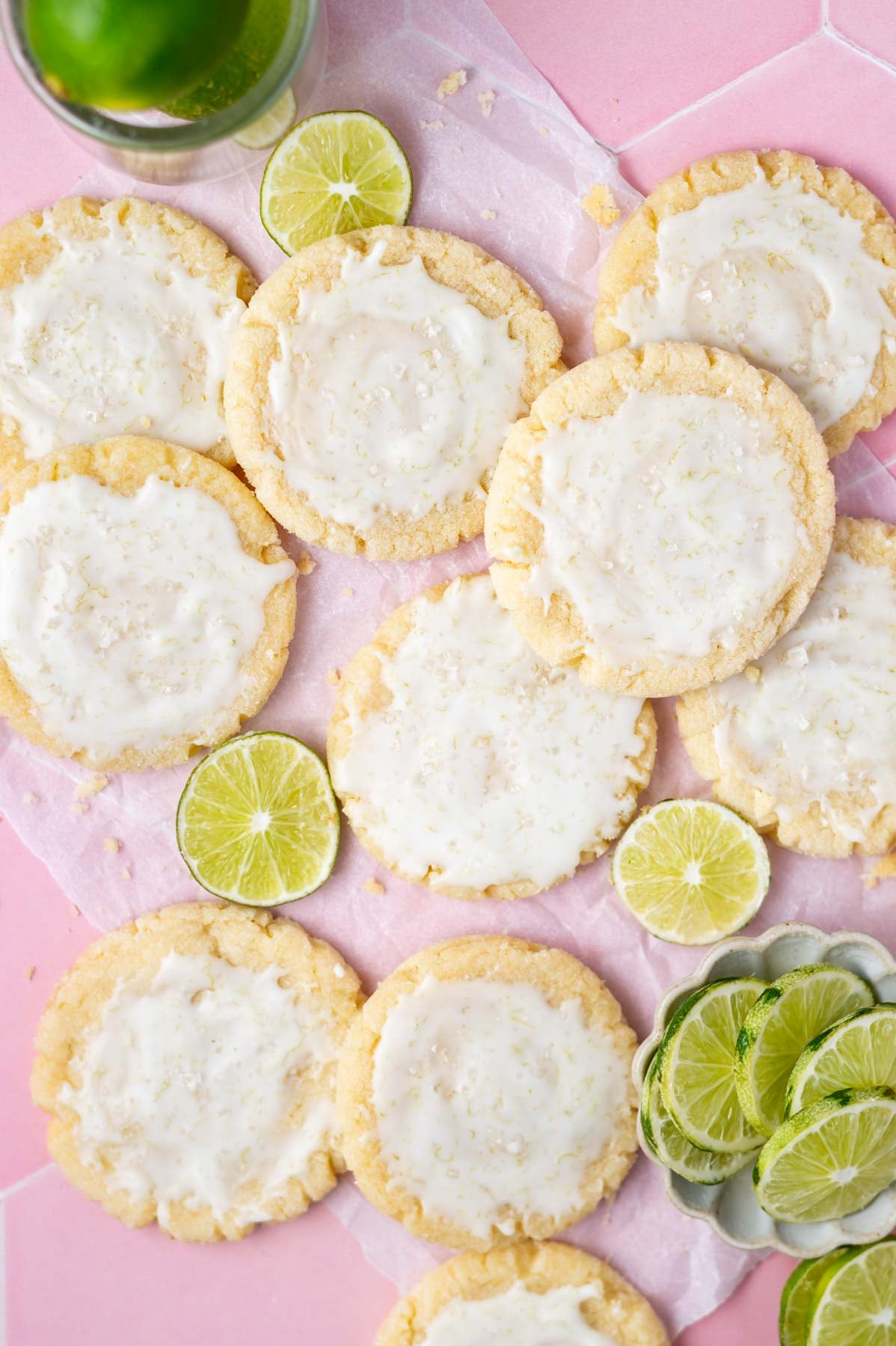 margarita cookies on a sheet of parchment paper with lime slices