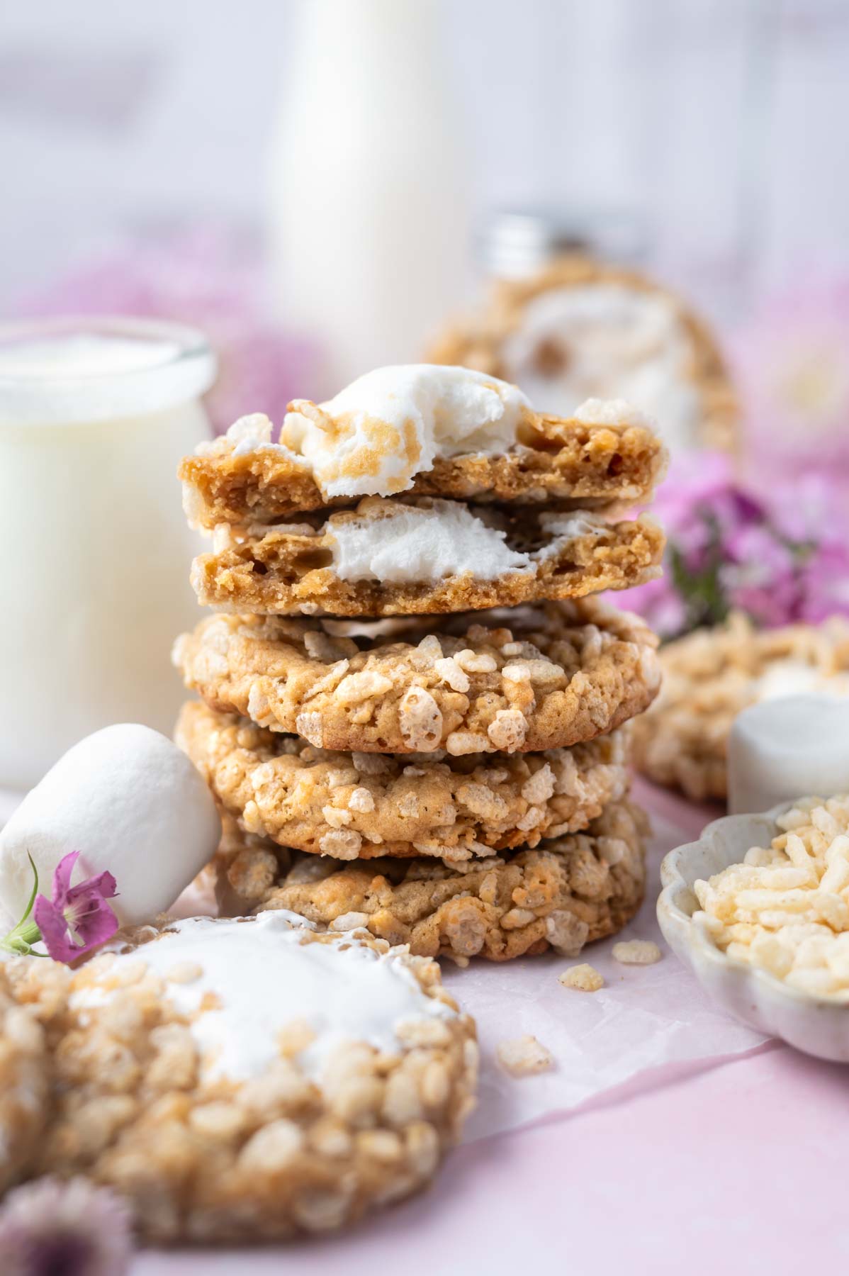 stack of rice crispy cookies with one broken open showing gooey marshmallow middle