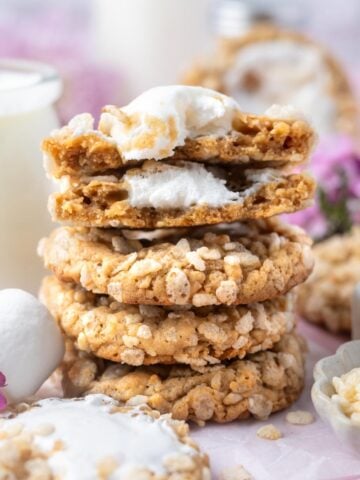 stack of rice crispy cookies with one broken open showing gooey marshmallow middle