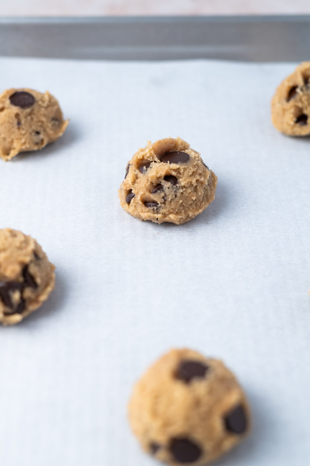 chocolate chip cookie dough on a parchment lined baking sheet