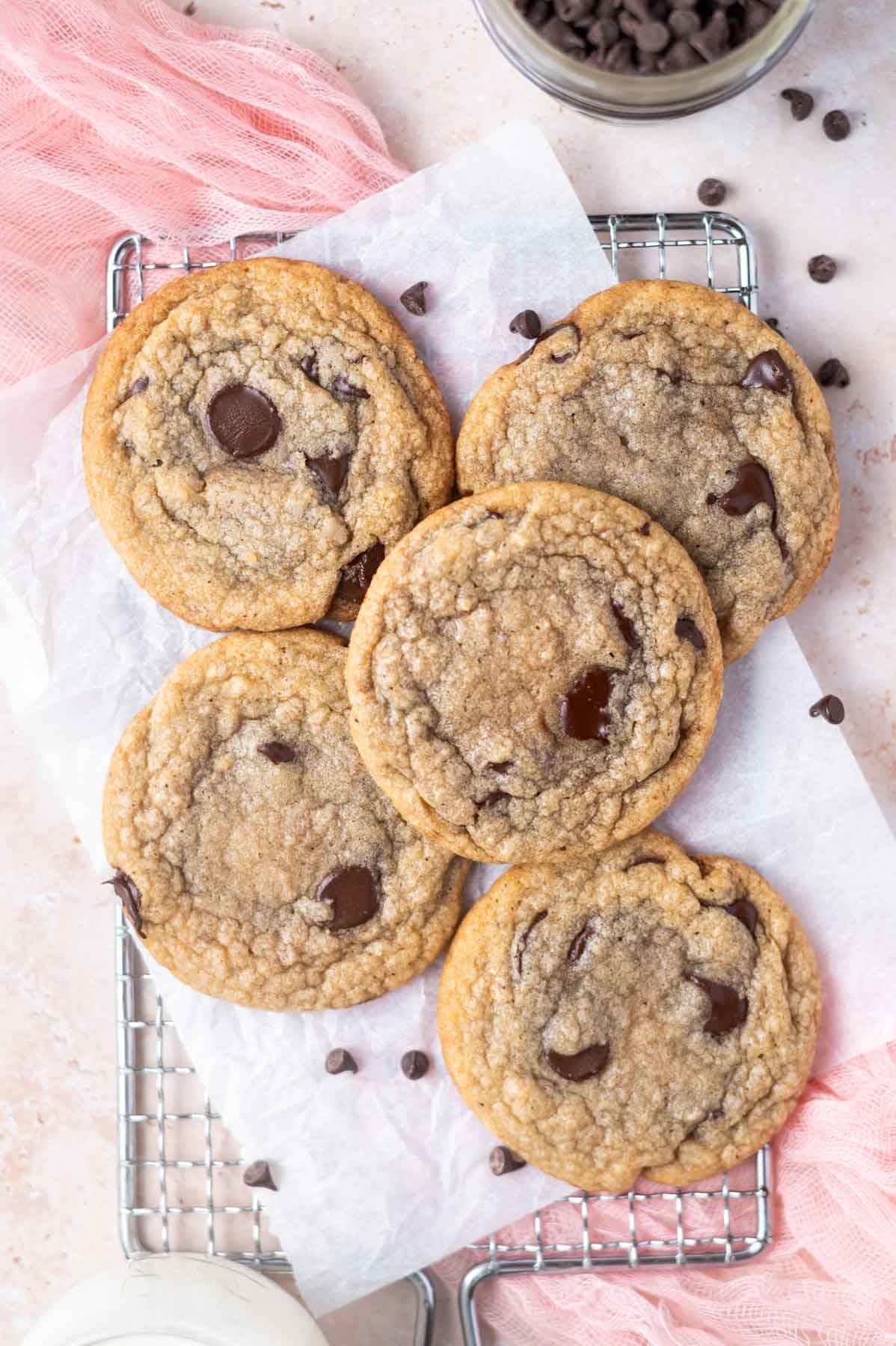 thin chocolate chip cookies on a parchment lined cooling rack