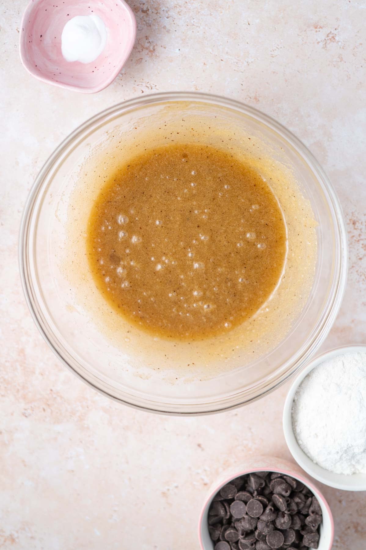 egg and vanilla added to melted butter and sugars in a glass bowl