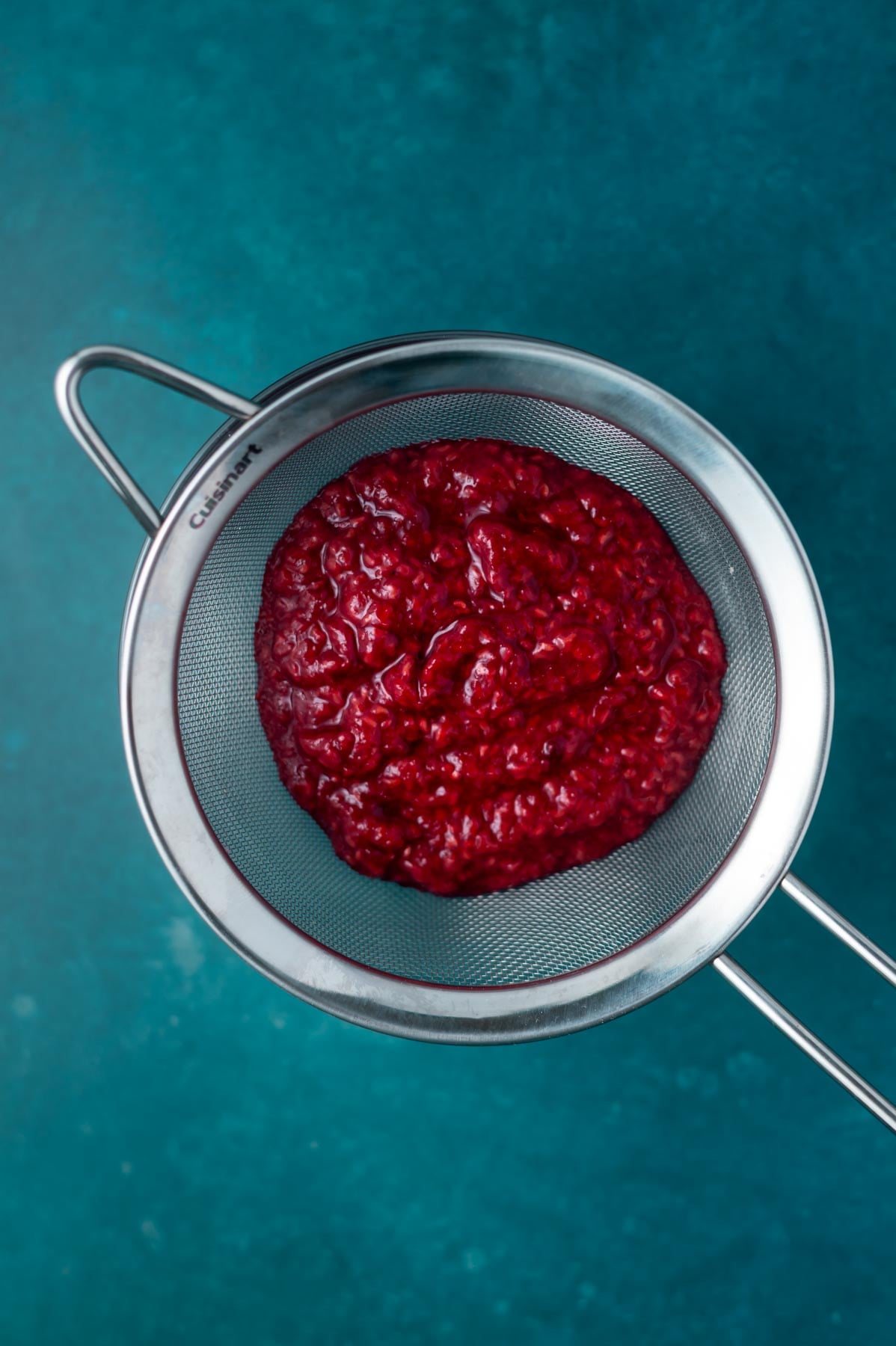 raspberry puree in a fine mesh stainer