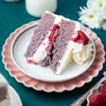 slice of raspberry cake with white chocolate buttercream on a plate