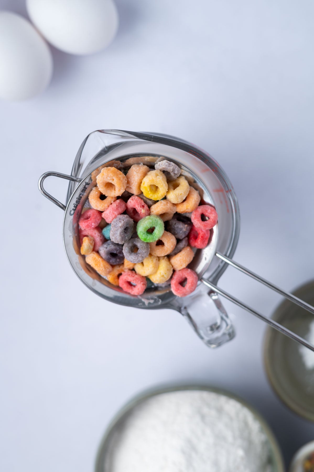 froot loops in a strainer set over a spouted measuring cup