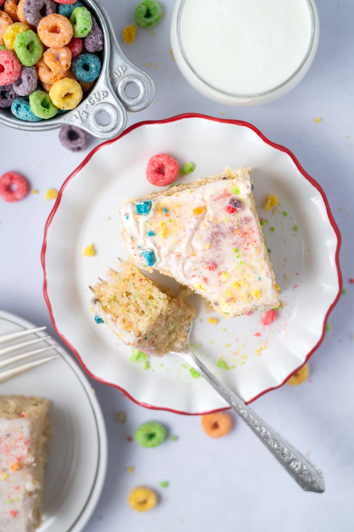 slice of cake on a plate with a bite on a fork and a glass of milk