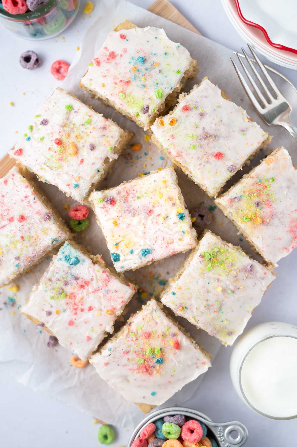 slices of cake on a parchment lined cutting board with froot loops
