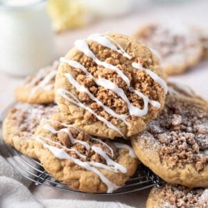 coffee cake cookies piled on a cooling rack with a glass of milk in the background