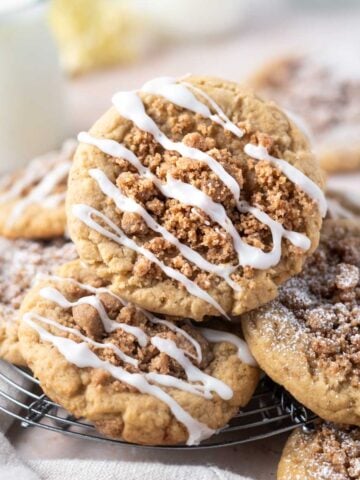 coffee cake cookies piled on a cooling rack with a glass of milk in the background