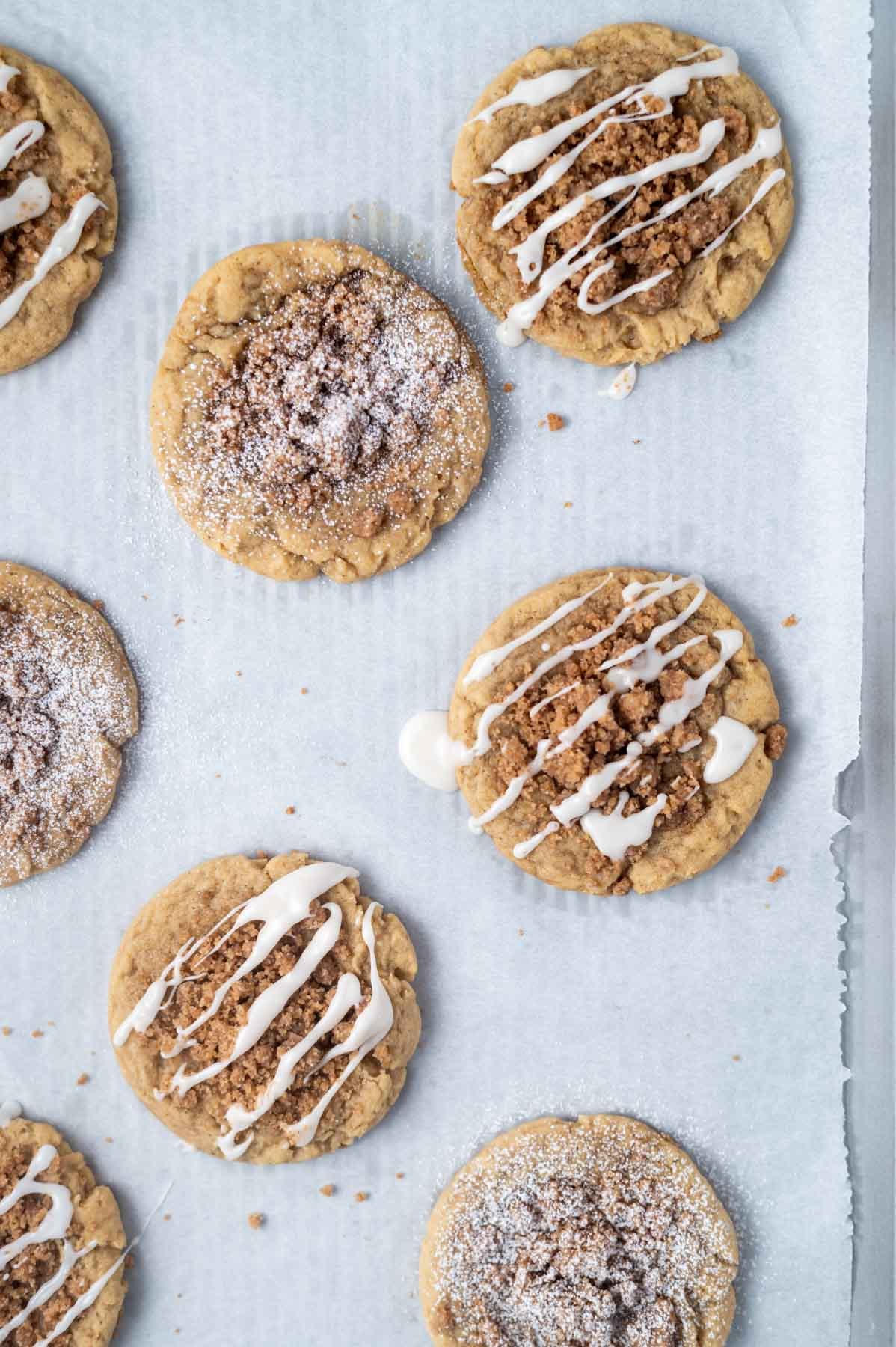 cookies with glaze and with confectioners' sugar on a parchment lined baking sheet