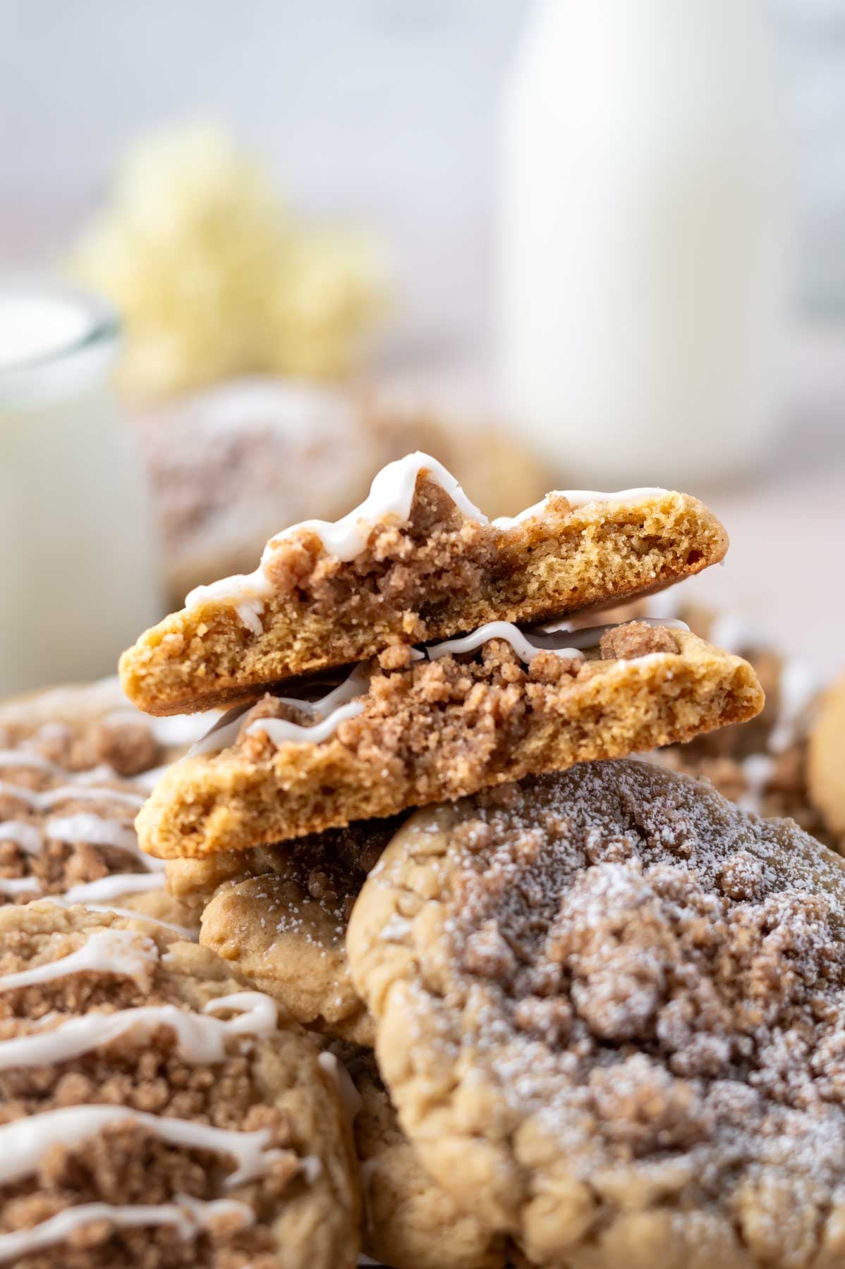 broken cookie pieces on top of a pile of cookies with milk in the background