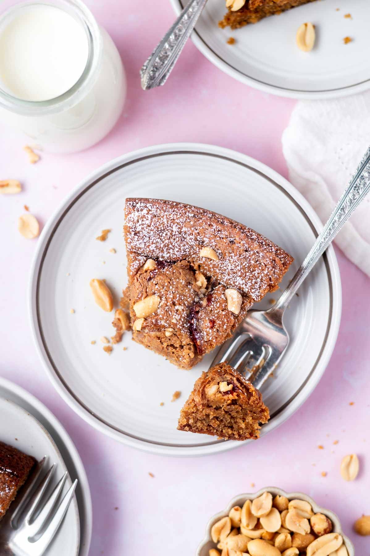 slice of cake on a plate with a bite on a fork