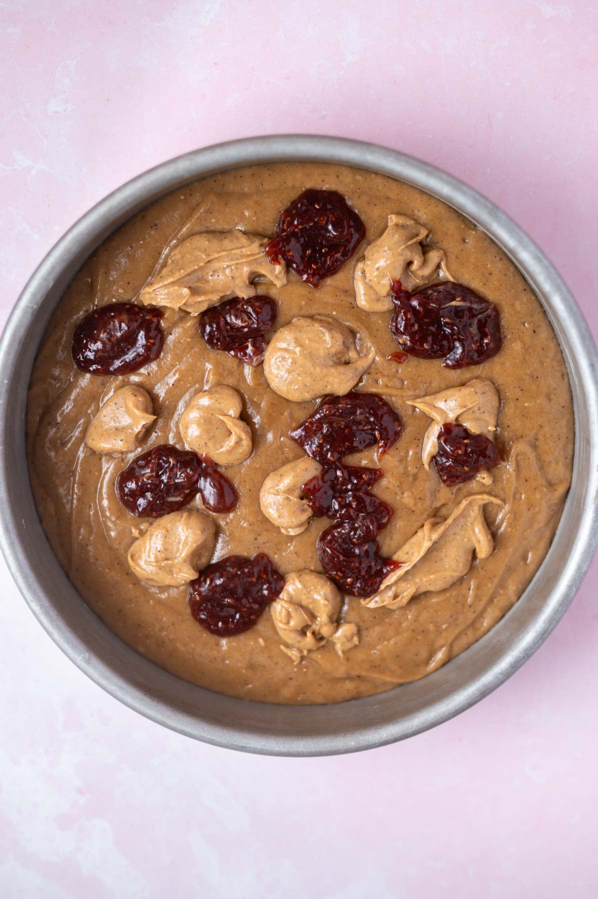 dollops of jam and peanut butter over cake batter