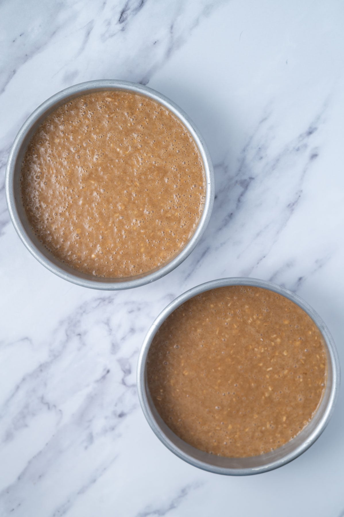 oatmeal cake batter in two round baking pans