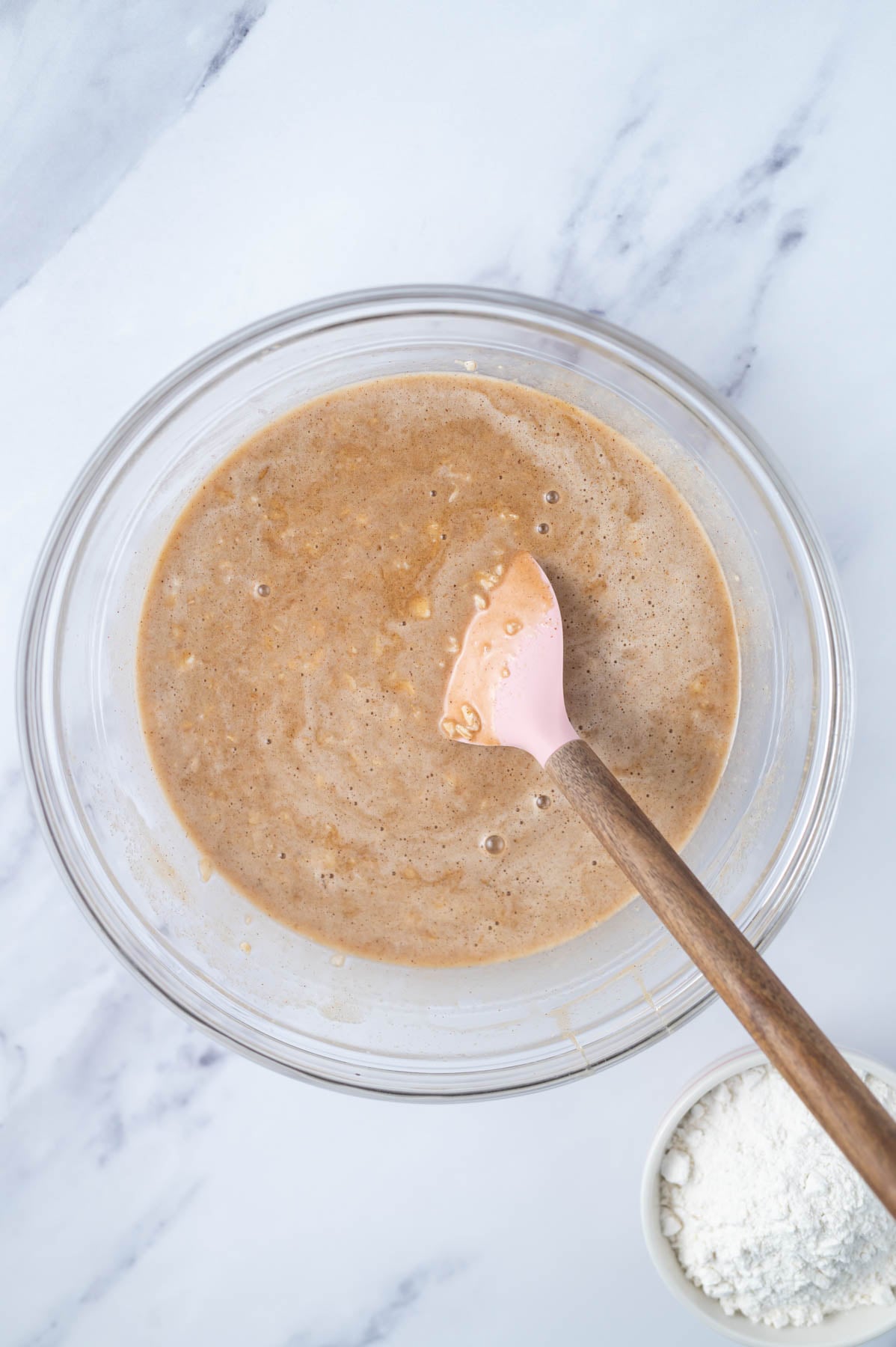 old fashioned oats mixed into cake batter with a spatula