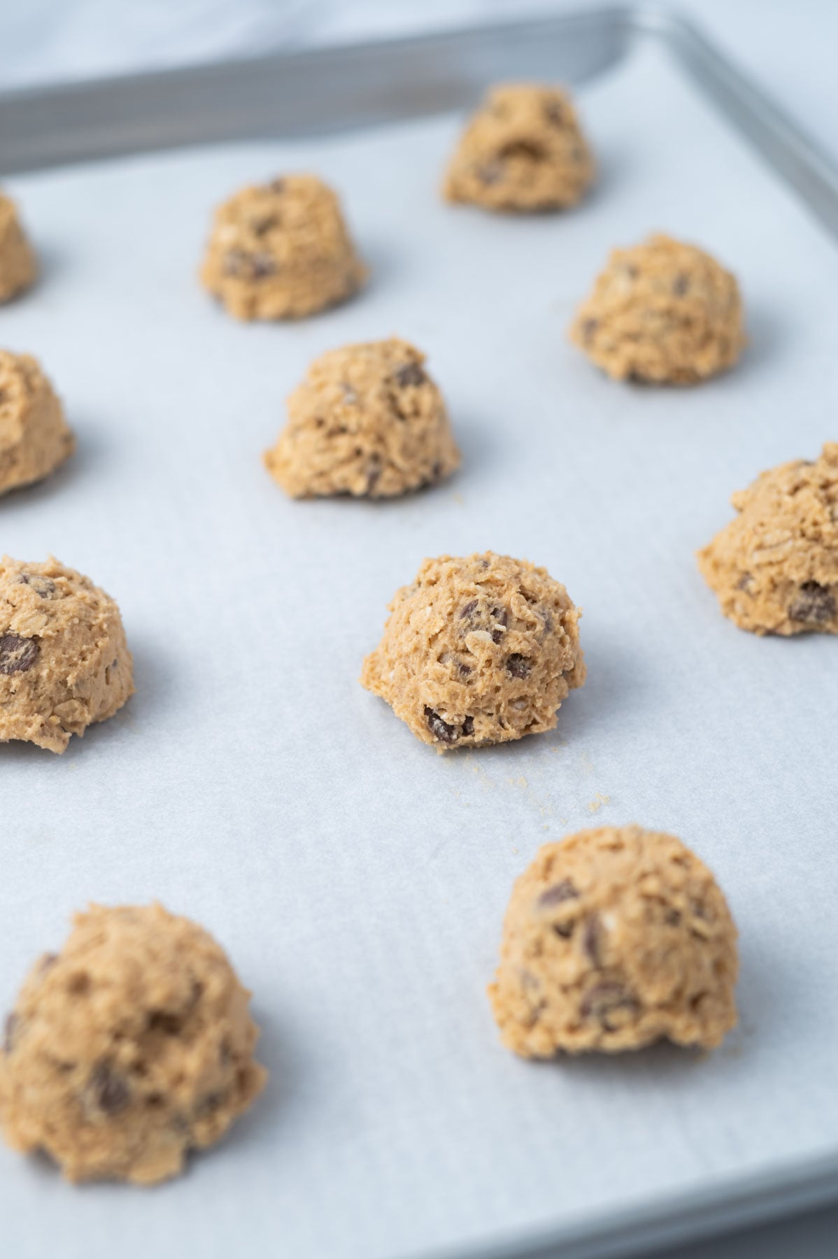 oatmeal peanut butter chocolate chip cookie dough on a parchment lined baking pan