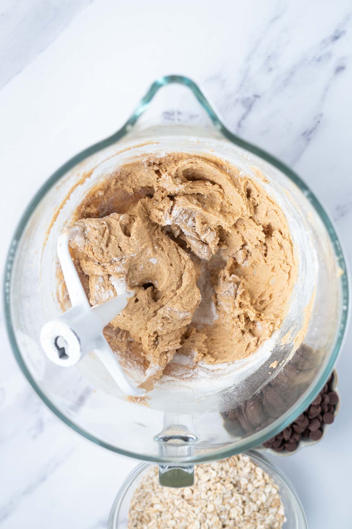 cookie dough in a mixing bow with some big streaks of flour remaining