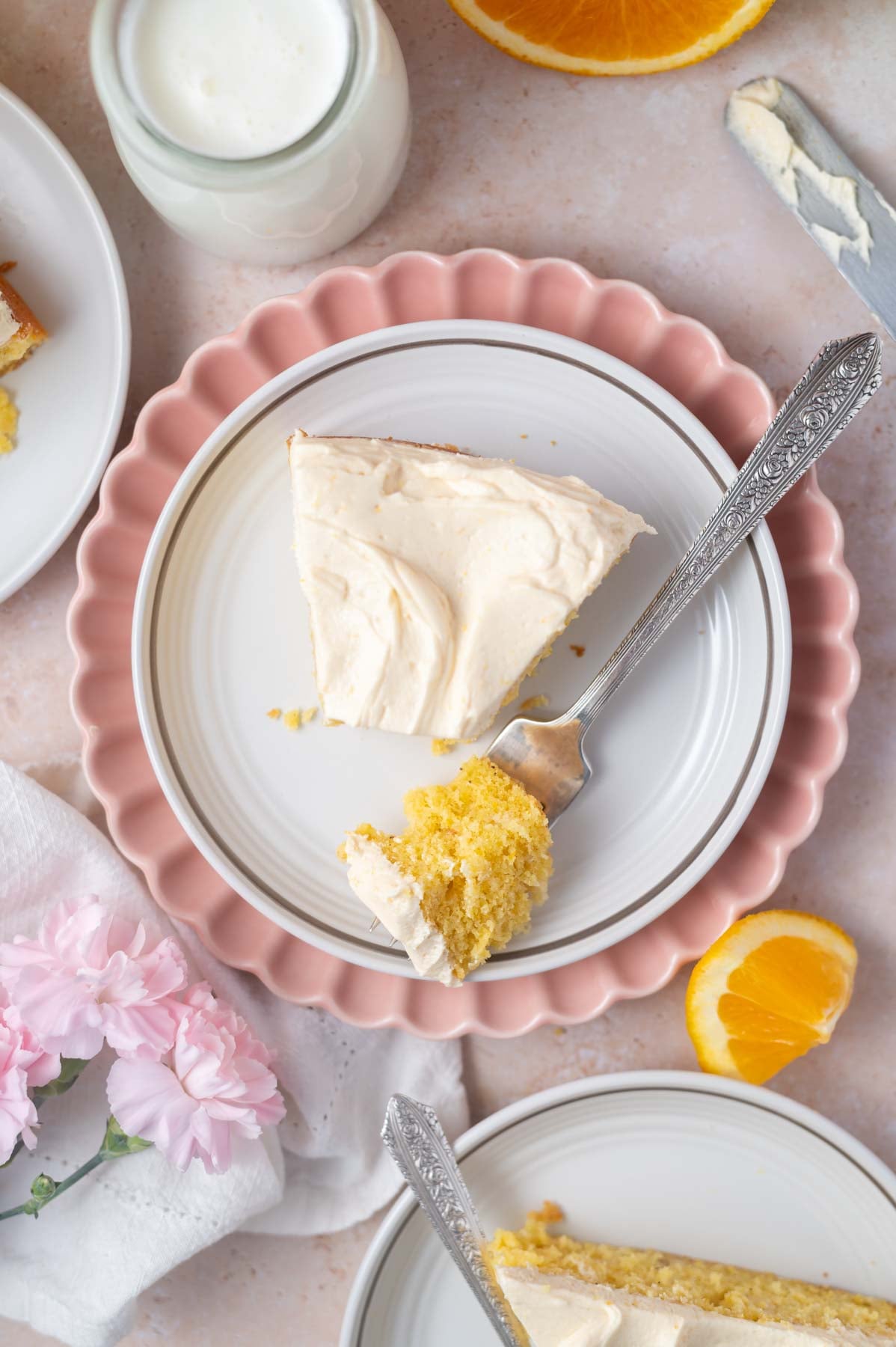 overhead look at orange creamsicle cake on a plate with a bite on a fork
