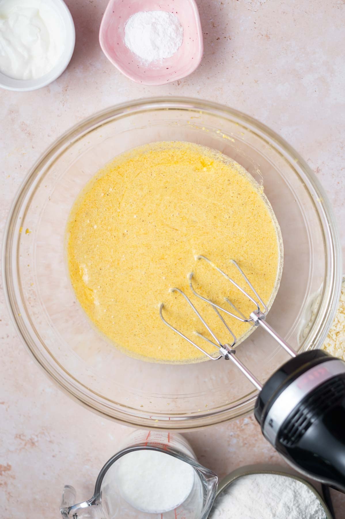 eggs, vanilla and orange juice added to cake batter in a bowl