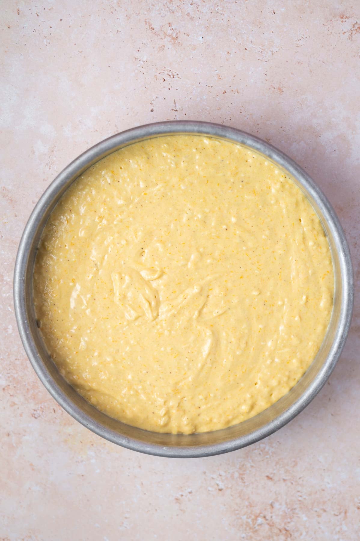 orange cake batter in a round baking pan