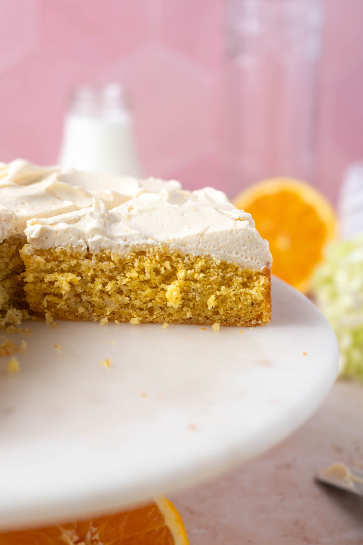 slices of orange creamsicle cake on a cake stand
