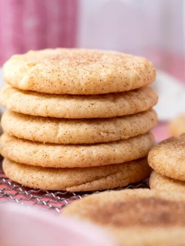 stack of thick, soft snickerdoodle cookies on a cooling rack