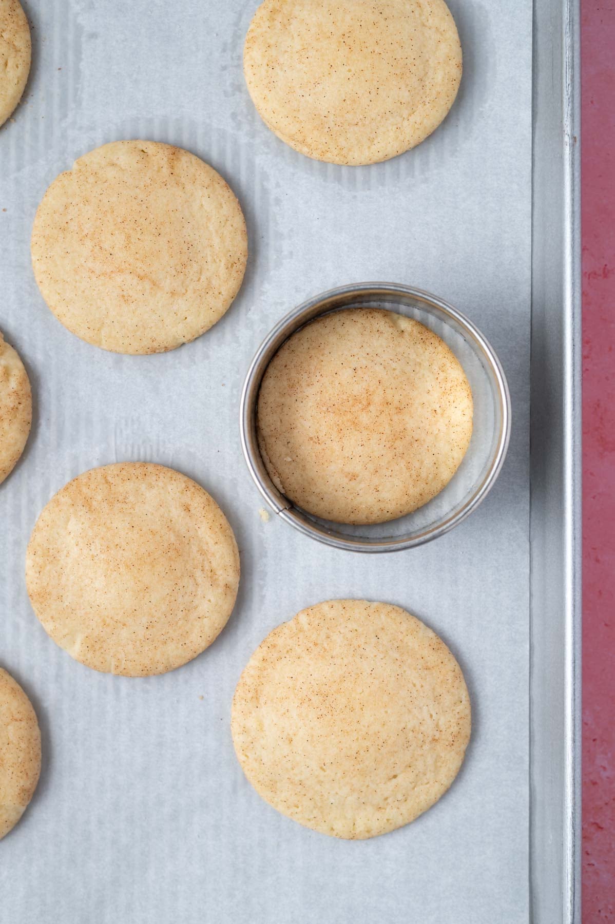 biscuit cutter scooting a cookie on a baking pan