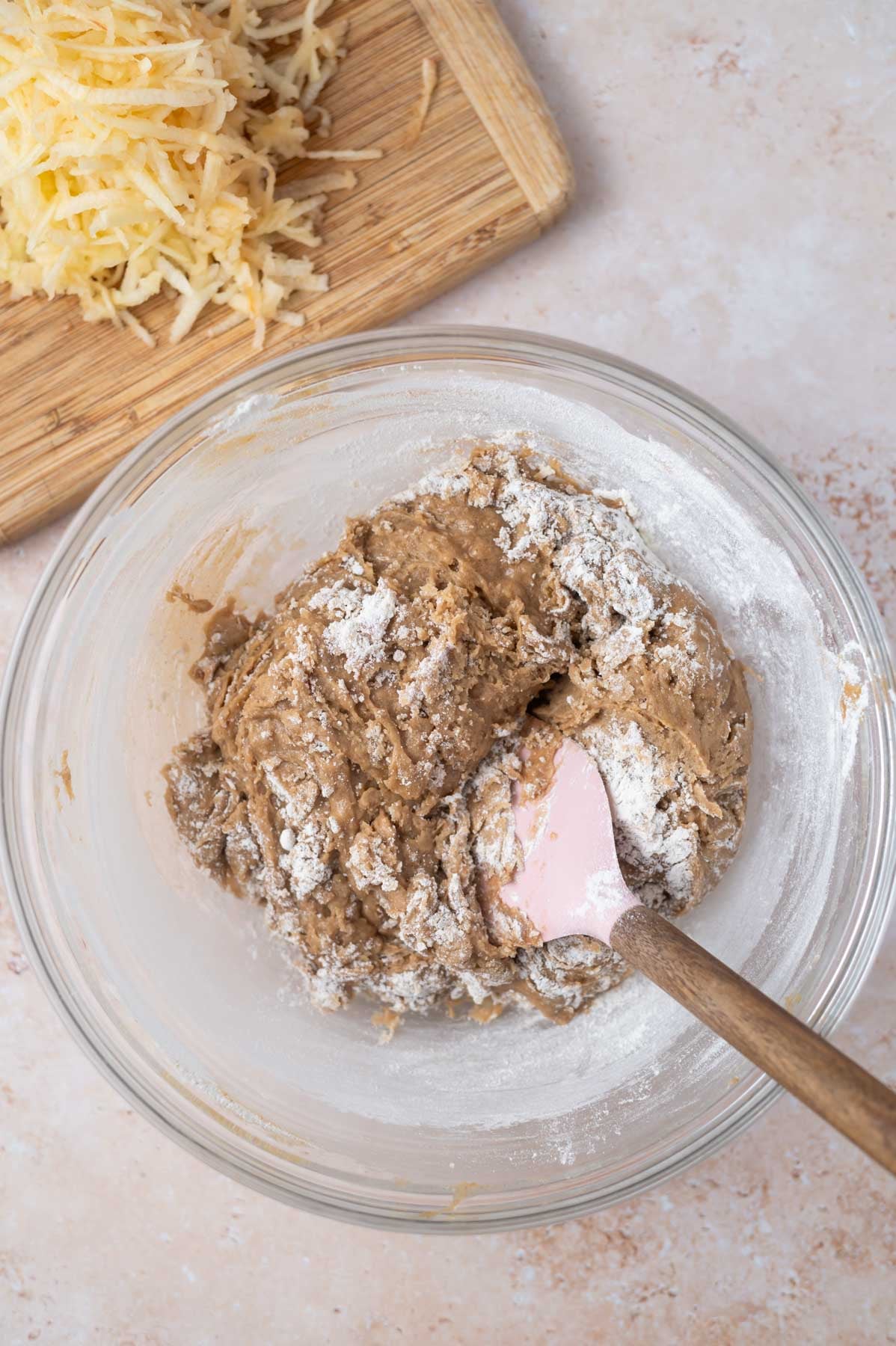 blondie batter in a glass bowl with large streaks of flour remaining