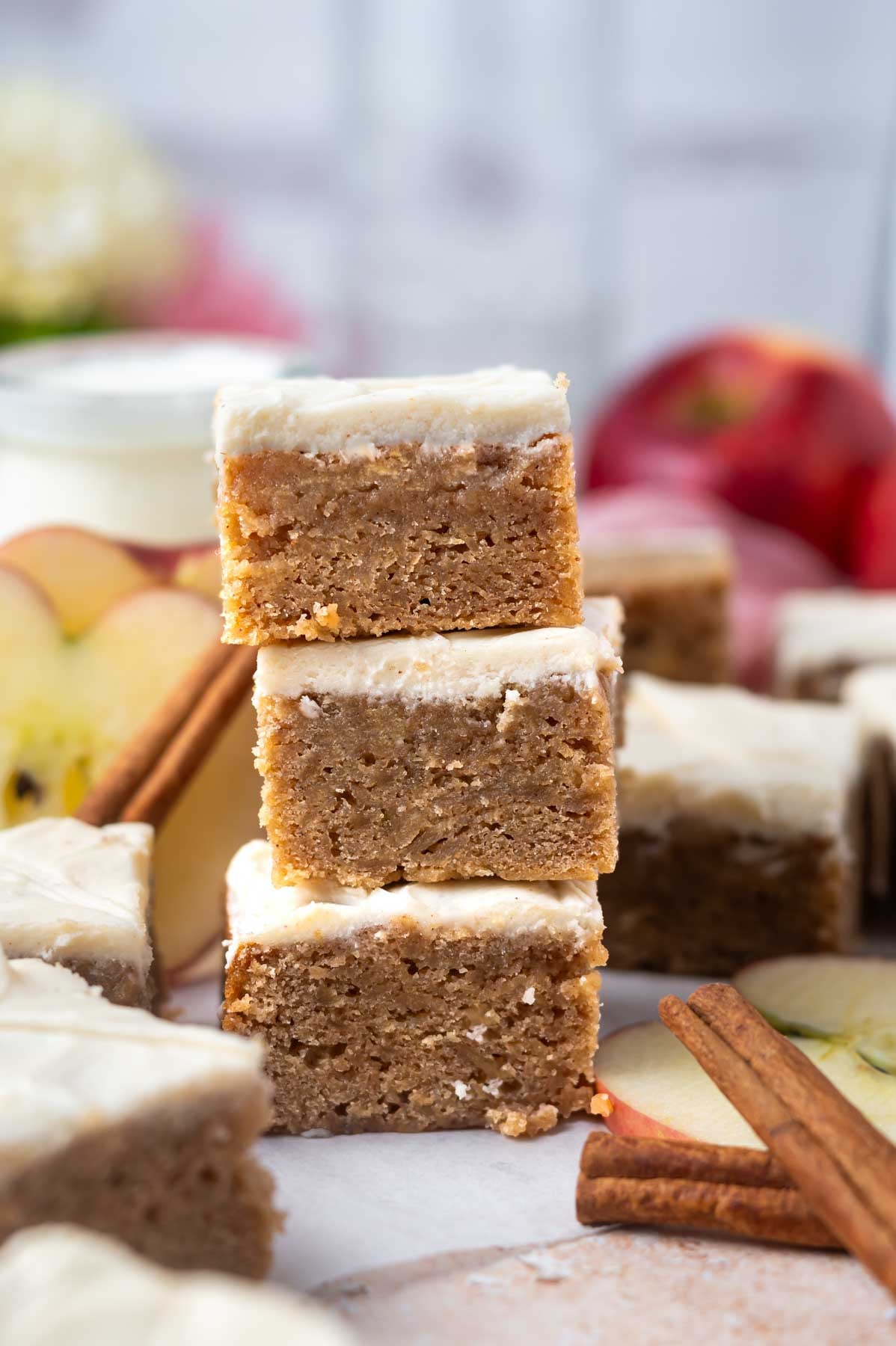 stack of blondies with apples in the background a cinnamon sticks