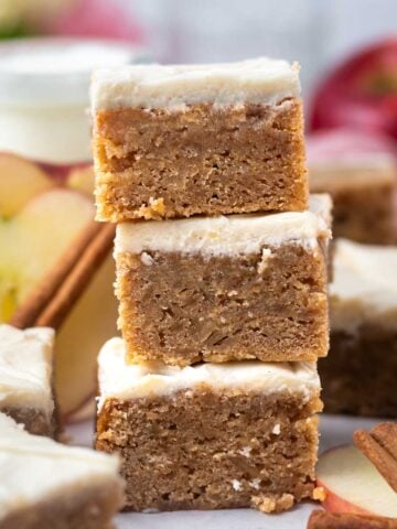 stack of blondies with apples in the background a cinnamon sticks