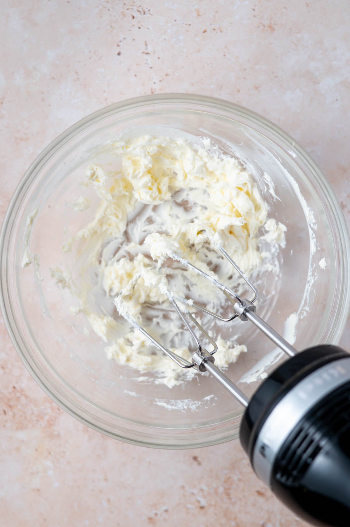 cream cheese softened with a hand mixer in a bowl