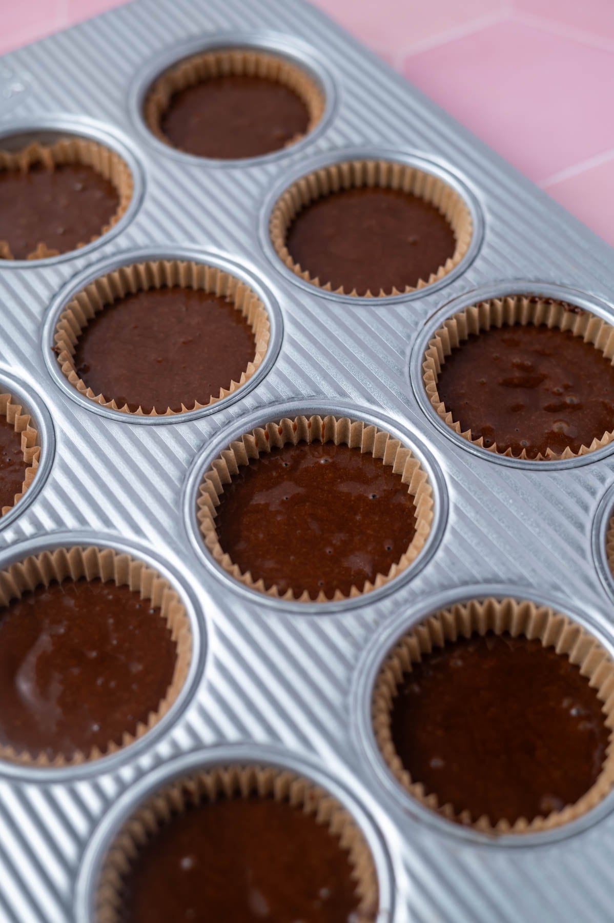 chocolate cupcake batter in a muffin tin with liners