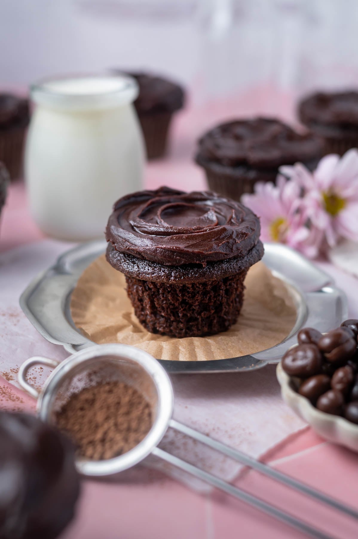 chocolate ganache cupcake on a plate with the wrapper off showing soft crumb