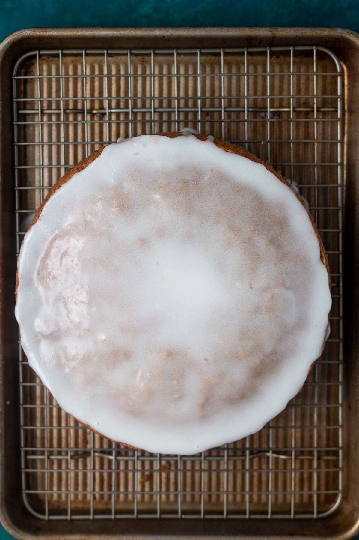 lemon glaze on top of cake on a cooling rack