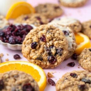 orange cranberry oatmeal cookies with orange slices and a bowl of dried cranberries