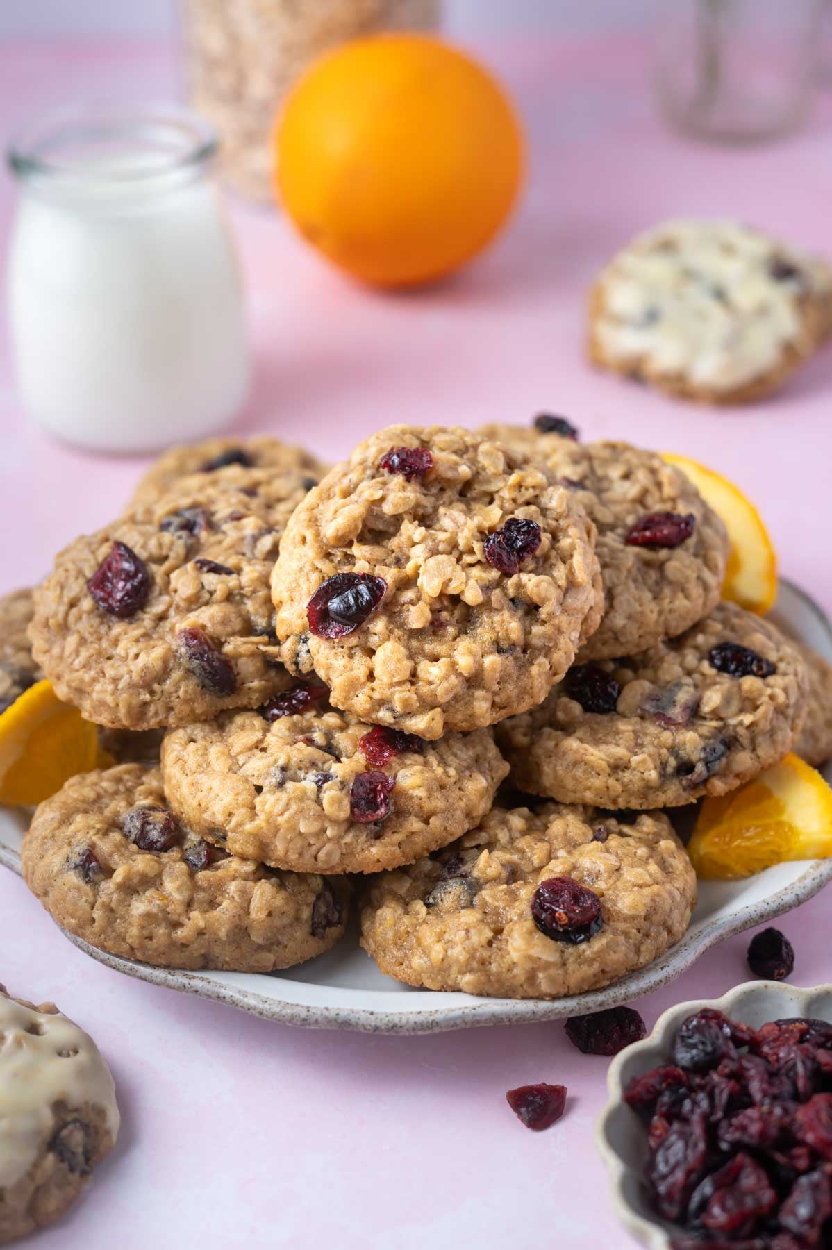 plate of cookies with milk and and orange in the background
