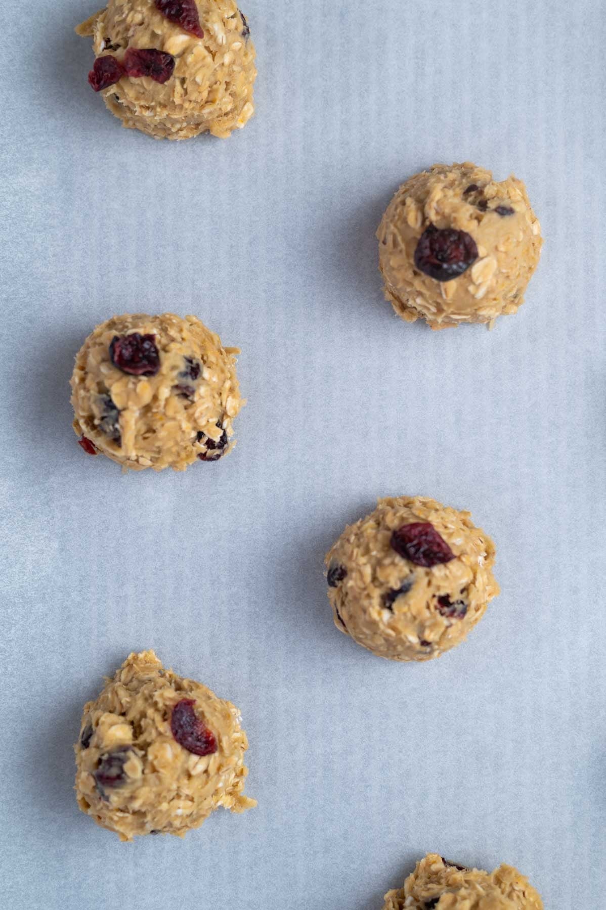 cookie dough balls on a parchment lined baking pan