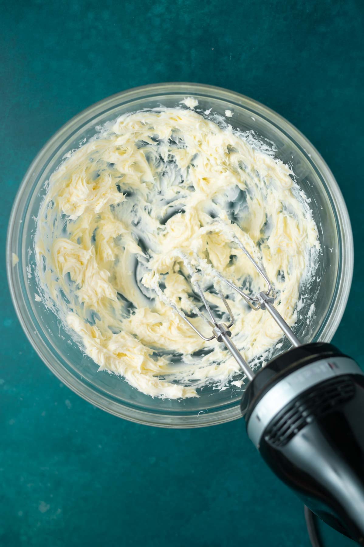 butter beaten with a hand mixer in a glass bowl