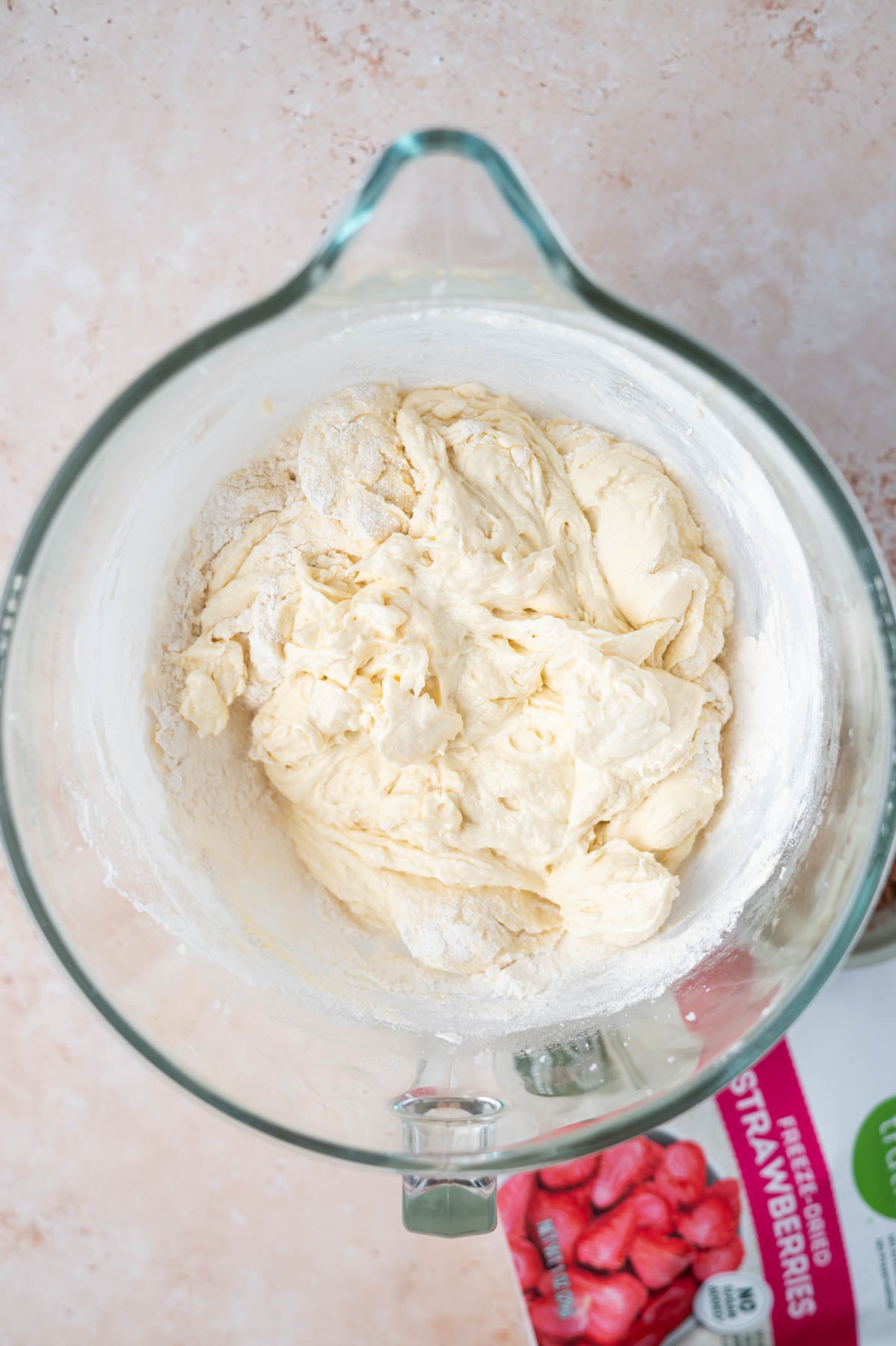cake batter in a bowl with a few streaks of flour still showing