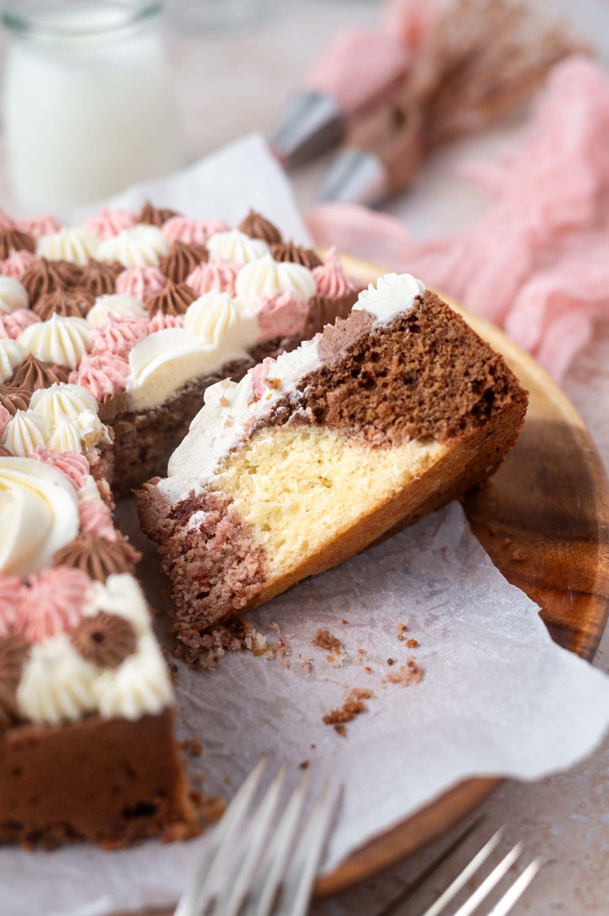 slice of cake on it's side, showing strawberry, vanilla, and chocolate flavors
