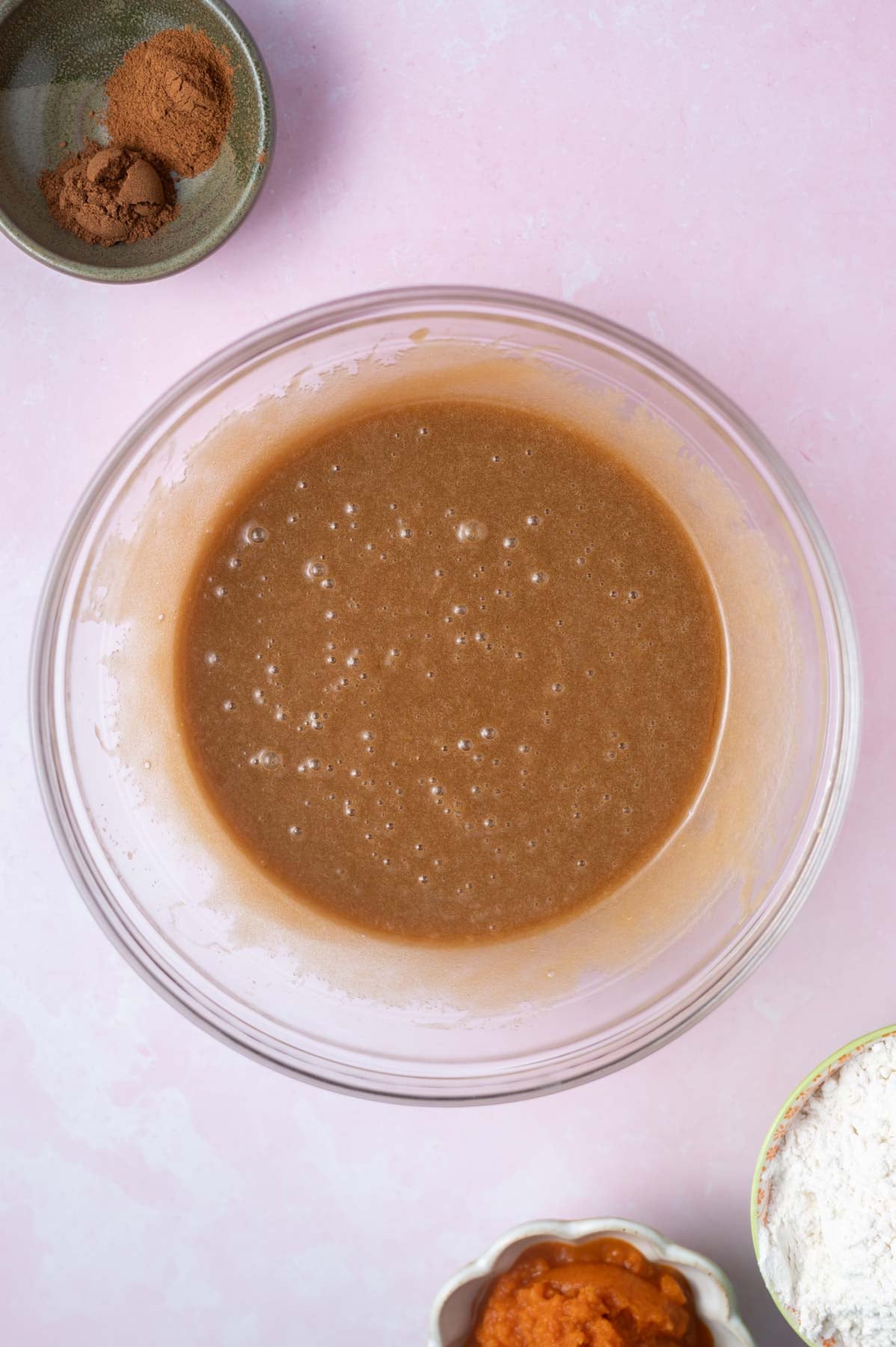 sugars, butter, vanilla, and eggs mixed together in a glass bowl