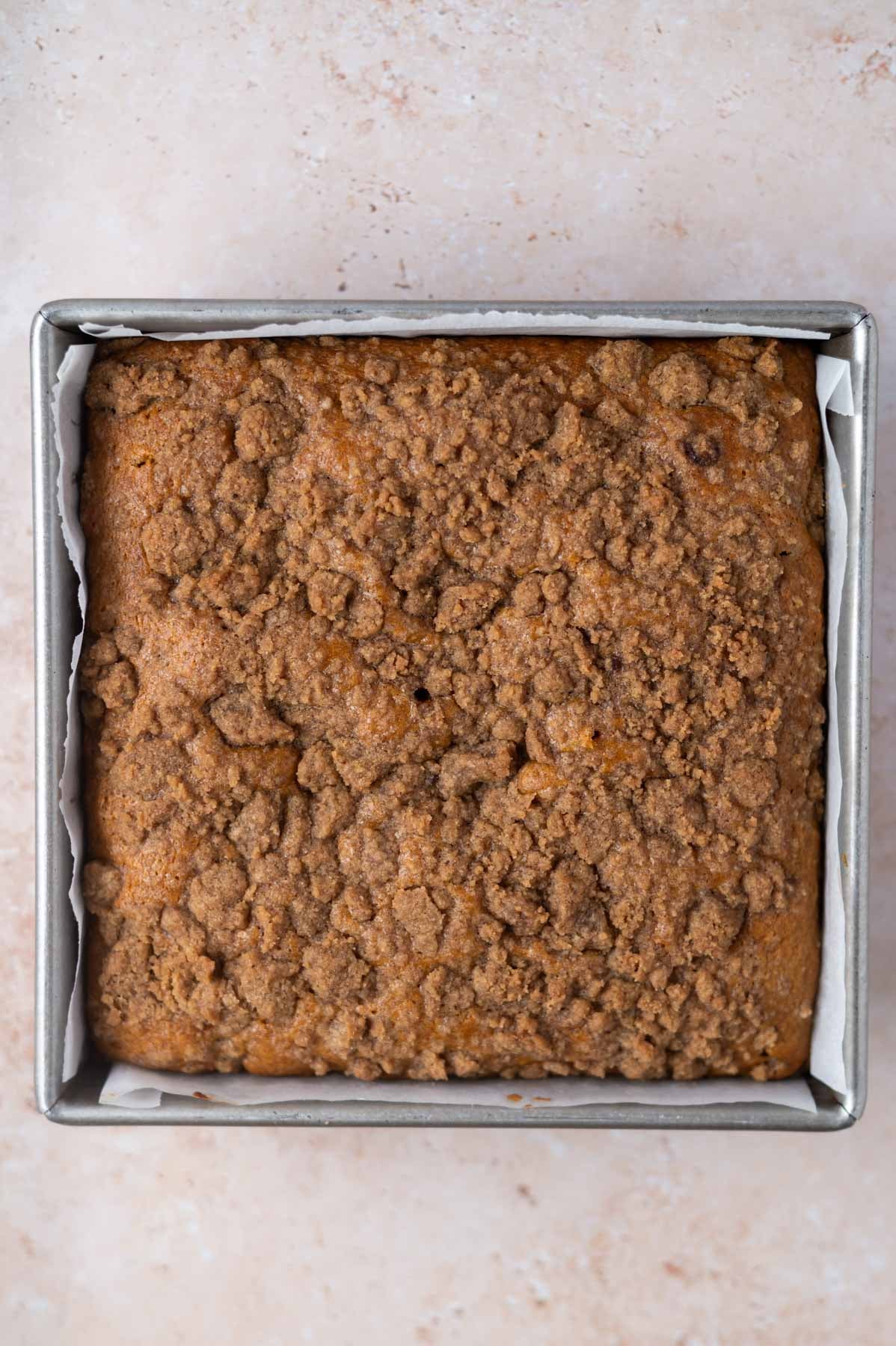 baked pumpkin coffee cake in a parchment lined pan