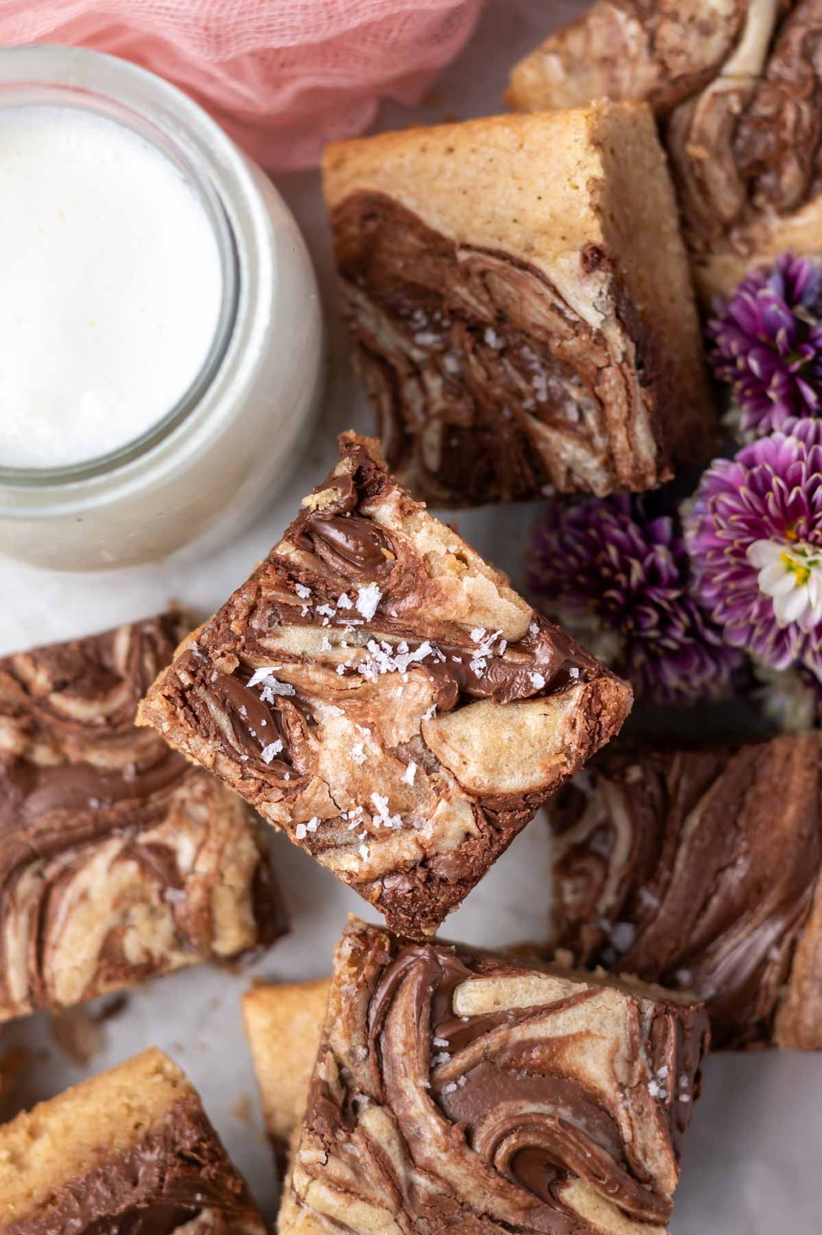 overhead look at swirled Nutella blondie with flaky sea salt on top and a glass of milk